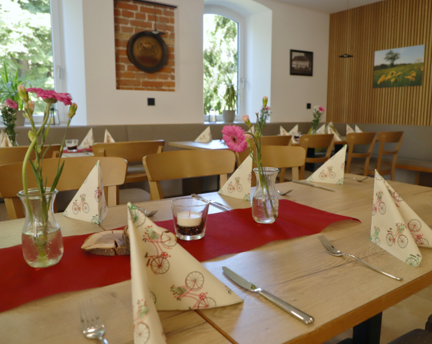 Hall with set tables, flowers, candles, and napkins
