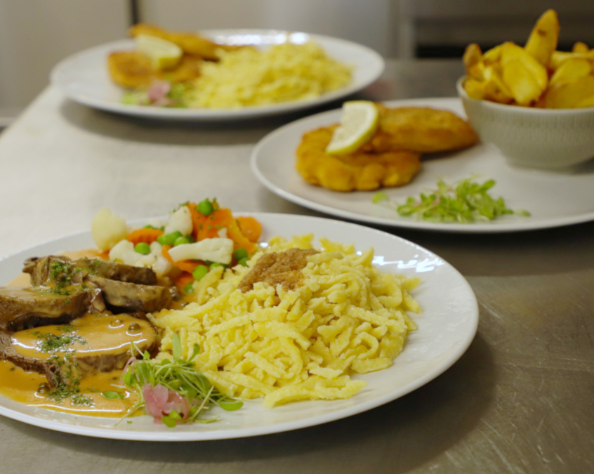 Braten mit Gemüse und Spätzle, Pommes und Schnitzel in der Küche